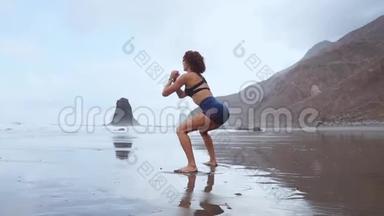 一位妇女在大西洋沿岸表演坐式节目。 健康生活方式的概念.. 参加体育运动